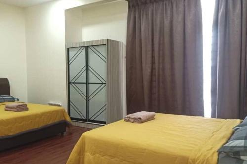 a bedroom with two beds with yellow sheets and a mirror at KS 80 Homestay (15pax)4R3B ~WiFi~ near Jetty in Kuala Selangor