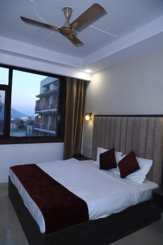 a bedroom with a large bed with a ceiling fan at The Divine Oak in Katra