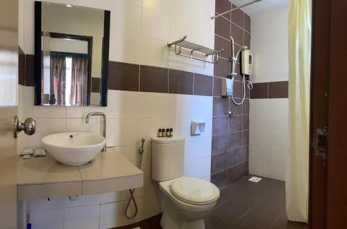 ein Badezimmer mit Toilette, Waschbecken und Spiegel in der Unterkunft Homestay 3 rooms suite Apartment 8-10pax at Amari Villa Bukit Katil, Ayer Keroh Melaka in Malakka