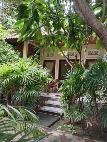 a house with stairs leading to the front door at Pondok Aldi Hostel in Amed