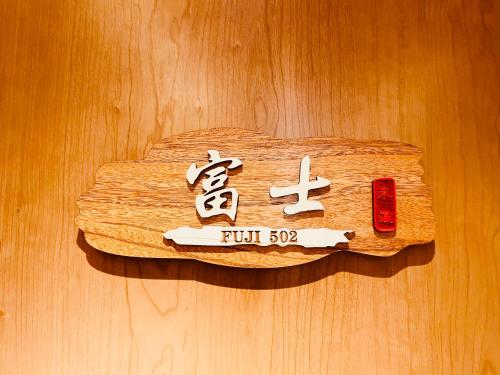 a sign on a wooden wall withinese writing on it at 東瀛 Stays502富士 お洒落な和室部屋 in Osaka