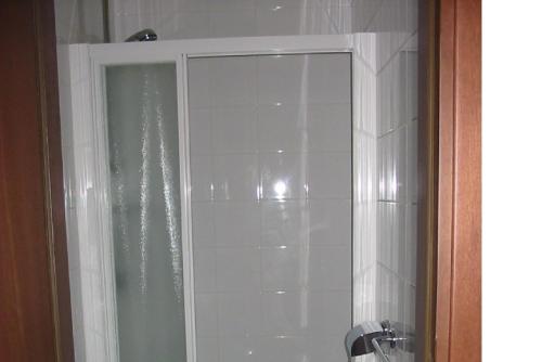 a bathroom with a shower with white tile at Hotel Antico Capon in Venice