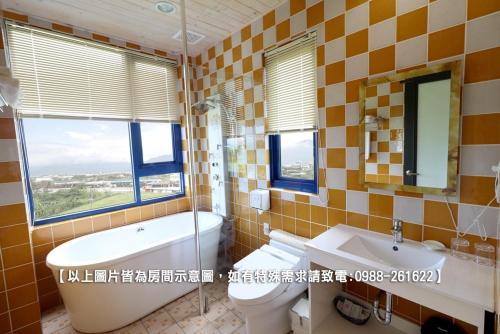 a bathroom with a tub and a toilet and a sink at Zen Ocean in Jian
