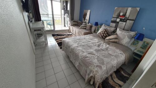 ein Schlafzimmer mit einem großen Bett und einem Spiegel in der Unterkunft LE BLUE GROUND in Le Diamant