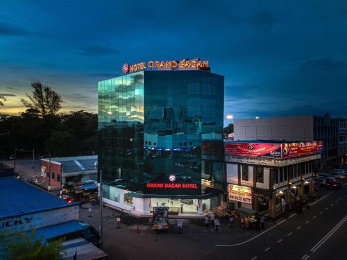 a large glass building with a sign on top of it at Grand Bagan Hotel in Butterworth