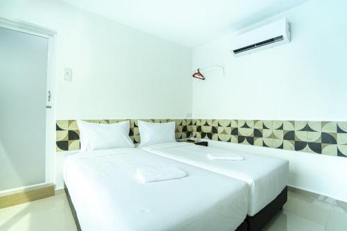 a white bedroom with a large white bed at Grand Bagan Hotel in Butterworth