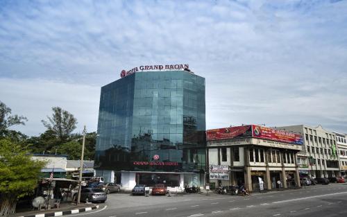 a tall glass building with a sign on top of it at Grand Bagan Hotel in Butterworth