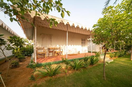 a house with a table and chairs in a yard at Madho Bagh in Sawāi Mādhopur