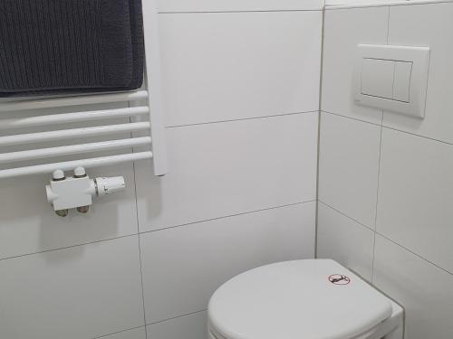 a bathroom with a white toilet and a toilet paper dispenser at Apartment Flora three in Duisburg