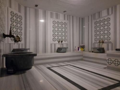 a bathroom with two sinks and a bath tub at Plaza Hotel Diyarbakir in Diyarbakır