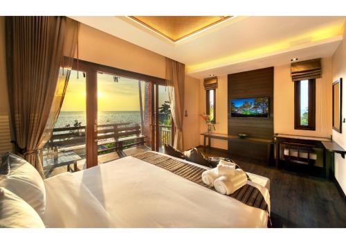 a bedroom with a bed with a view of the ocean at Nirvana Beach Resort, Koh Lanta SHA Extra Plus in Ko Lanta