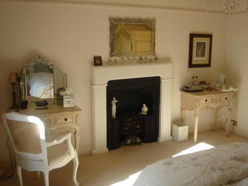 a bedroom with a fireplace and a bed and a mirror at Littlebank Country House in Settle