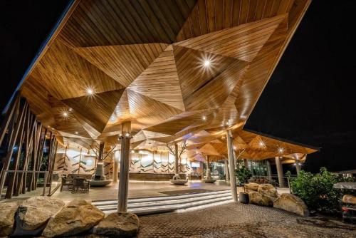 a building with a wooden ceiling with lights at Kalima Resort and Villas Khao Lak - SHA EXTRA PLUS in Khao Lak