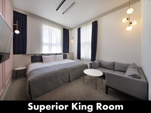 小樽市にあるアンワインド ホテル&バー 小樽のベッドとソファ付きのホテルルーム