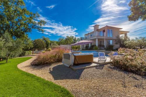 a house with a pool and a tv in the yard at Villa Roko in Malinska