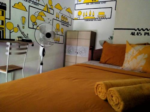 a bedroom with an orange bed with a fan at Banana Homestay in Banyuwangi