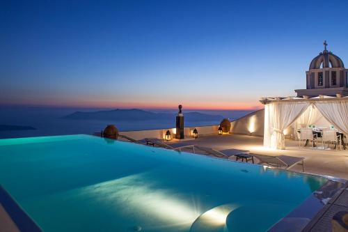 a pool on the roof of a house with a lighthouse at The Tsitouras Collection in Firostefani