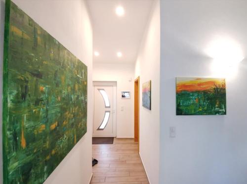 a hallway with paintings on the walls at Apartment Waldblick vom Naturhof Usedom in Bannemin
