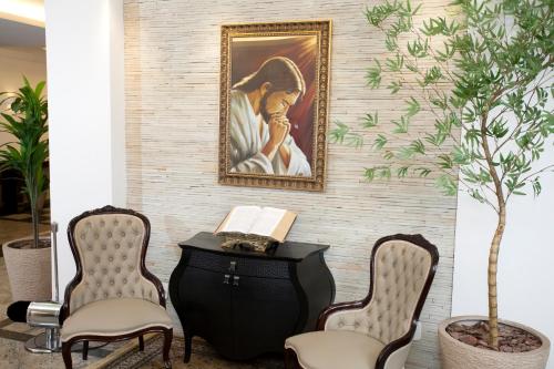 a room with two chairs and a painting on the wall at Laguna Plaza Hotel in Brasilia