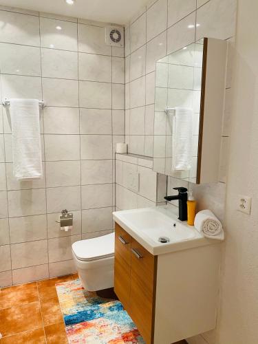 a bathroom with a toilet and a sink and a mirror at Akomo Bern in Bern