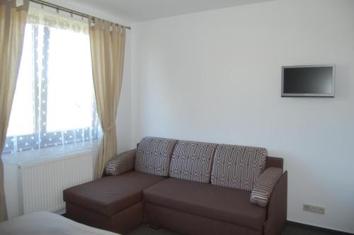 a living room with a couch and a window at RELAX PENZIÓN J&L in Pavčina Lehota