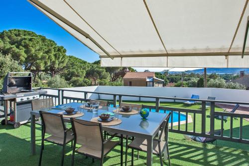 un patio con tavolo, sedie e griglia di Villa casa Luna piscine chauffée vue mer proche centre et plage de Calvi a Calvi