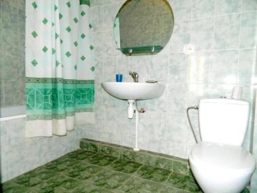 a bathroom with a sink and a toilet and a mirror at Славна Кача in Odesa
