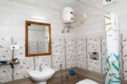 a bathroom with a sink and a toilet and a mirror at VALIYATH HOLIDAYS HOMESTAY in Munroe Island