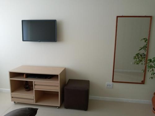 sala de estar con TV en la pared en Apartamento frente ao mar, en Balneário Camboriú