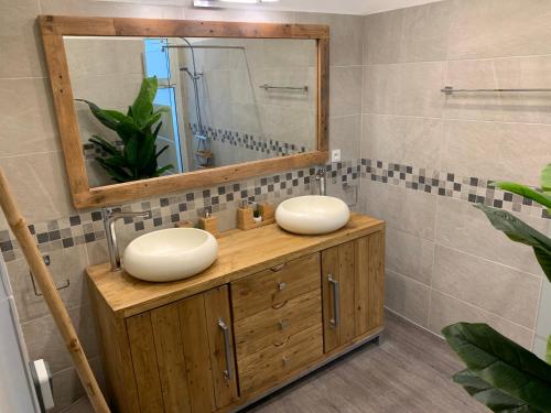 a bathroom with two sinks and a mirror at Villa Miss Satô in Ravine des Cabris