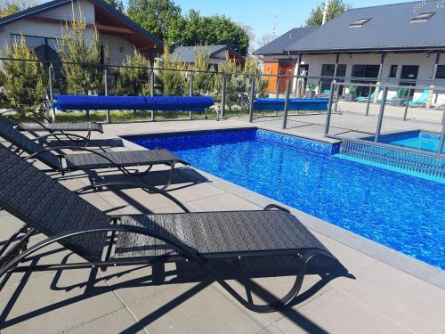 a swimming pool with two benches next to a swimming pool at Jastrzębia Port in Jastrzębia Góra