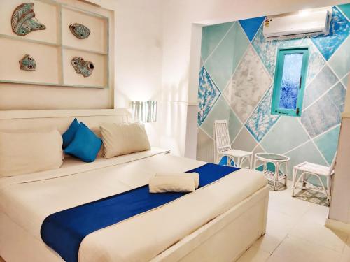 a bedroom with a bed with blue and white at Eros Boutique Hotel in Baga