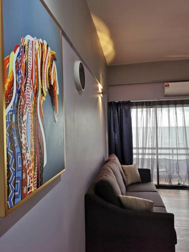 a living room with a couch and a painting of a horse at Tanjung Tuan Beach Regency - Hermis Theme 1 Car Park in Kampong Baharu