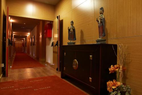 a hallway with two statues on top of a cabinet at Hotel Restaurante El Valles 4 ESTRELLAS in Briviesca