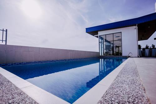 a swimming pool in front of a house at ibis Styles Kota Bharu in Kota Bharu