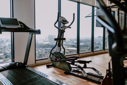 a gym with a treadmill in a room with windows at ibis Styles Kota Bharu in Kota Bharu