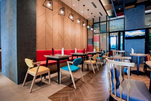 a restaurant with tables and chairs in a room at ibis Styles Kota Bharu in Kota Bharu