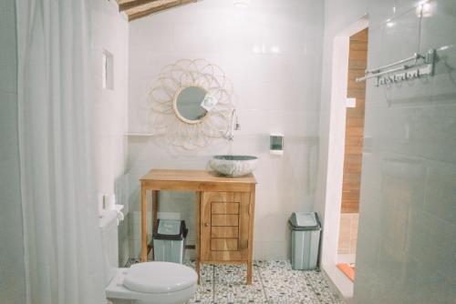 a bathroom with a sink and a toilet and a mirror at Mertasari Bungalows in Nusa Penida