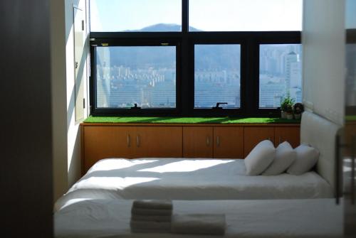 a bedroom with a bed and a large window at Samseong Coexmall AA in Seoul
