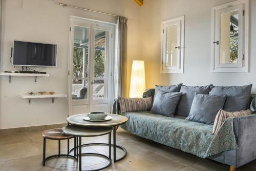 a living room with a blue couch and a table at Aelia Cottage in Mánganos