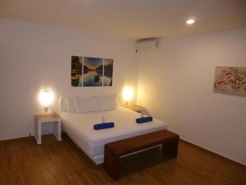 1 dormitorio con 1 cama blanca y 2 lámparas en Villa Marilu B&B en Bacalar