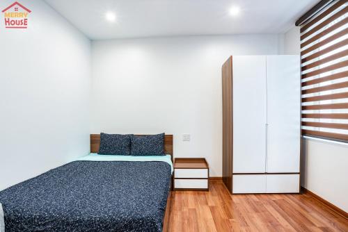 a bedroom with a bed and a white cabinet at Merry House Imperia in Hai Phong