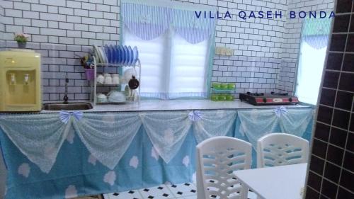a kitchen with a blue and white table and chairs at Villa Qaseh Bonda in Kuala Terengganu