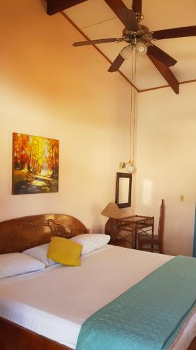 a bedroom with a bed with a ceiling fan at Samara Beach Hotel in Sámara