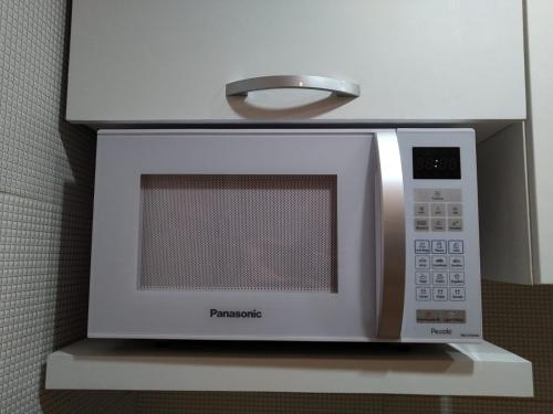 a microwave oven sitting on top of a shelf at Flat beira mar, Olinda 4 Rodas 309 in Olinda