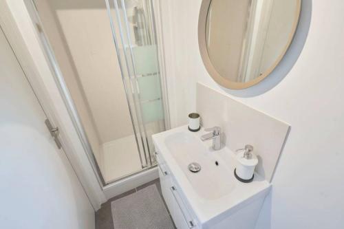a white bathroom with a sink and a mirror at LocationsTourcoing - Le Loir in Tourcoing