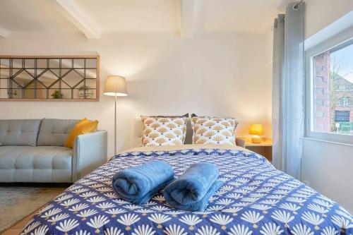 a bedroom with a bed with blue pillows on it at LocationsTourcoing - Le Loir in Tourcoing