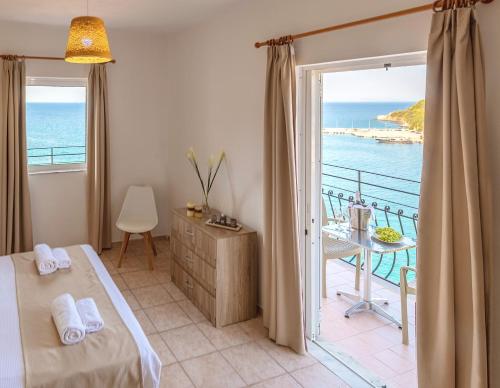 a bedroom with a bed and a view of the ocean at Faro Del Porto in Póros Kefalonias