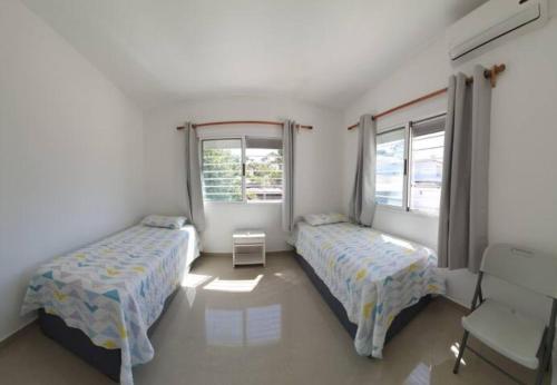 2 camas en una habitación con 2 ventanas en Casa a 1 cuadra de la playa en Punta del Este, en Punta del Este