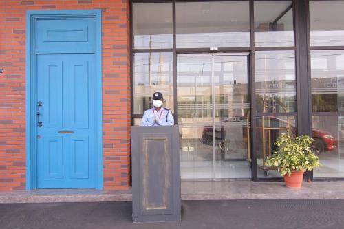 a man wearing a mask standing behind a podium in front of a building at Fortel in Chennai